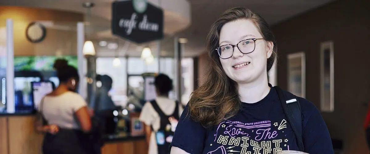 Student holding drink outside Cafe Diem