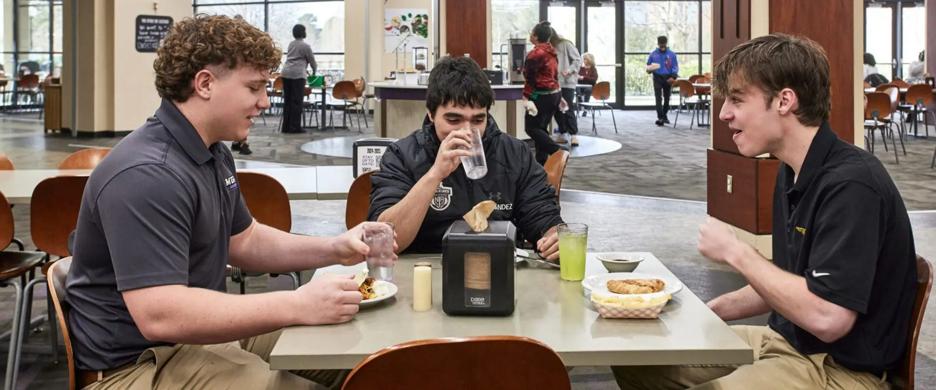 students conversing while eating at dining hall
