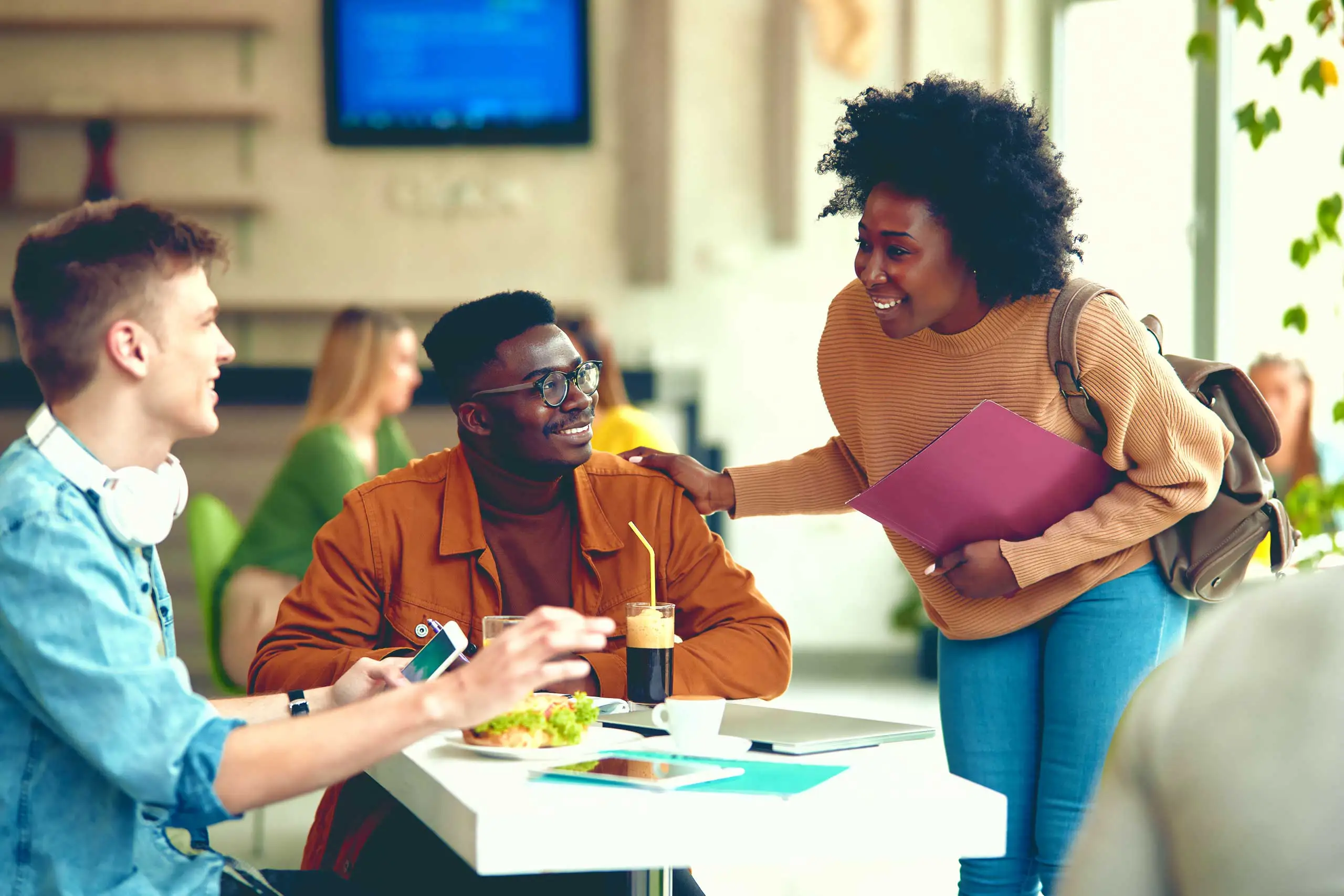 Three students having a conversation in dining room